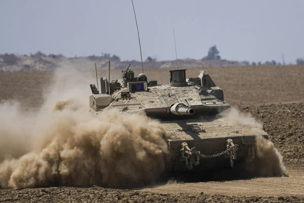 Soldati israeliani guidano un carro armato vicino al confine tra Israele e Gaza, nel sud di Israele