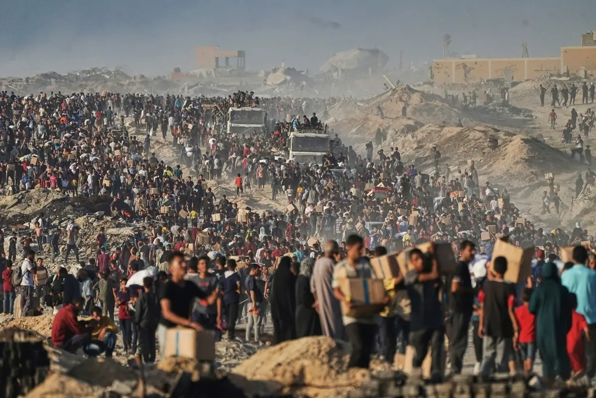 People carry sacks and boxes of food and humanitarian aid that was unloaded from a World Food Program convoy that had been heading to Gaza City in the northern Gaza Strip, Monday, June 16, 2025. (AP Photo/Jehad Alshrafi) Associated Press/LaPresse , APN