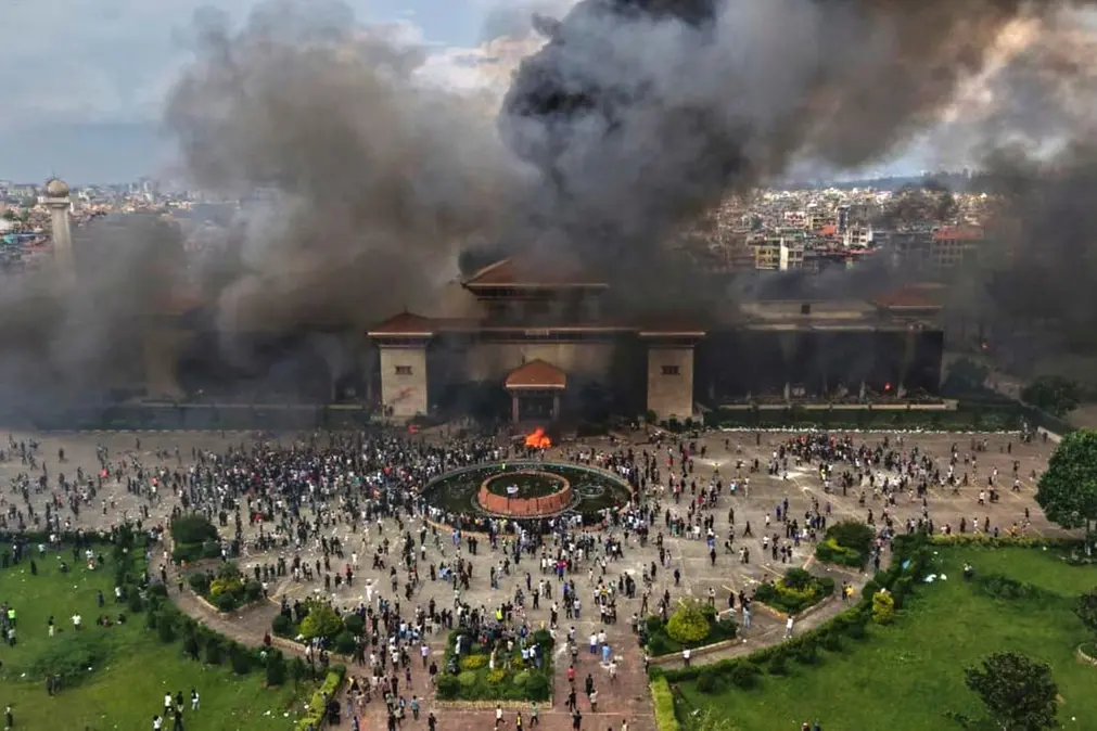 Protesters celebrate at the Singha Durbar, the seat of Nepal\\'s government\\'s various ministries and offices after it was set on fire during a protest against social media ban and corruption in Kathmandu, Nepal, Tuesday, Sept. 9, 2025. (AP Photo/Prakash Timalsina) , APN