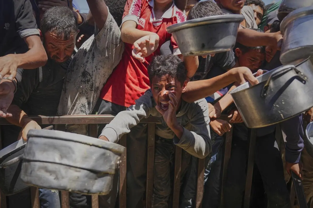 Palestinians struggle to receive cooked food distributed at a community kitchen in the Muwasi area of Khan Younis, in the Gaza Strip, Friday, May 23, 2025. (AP Photo/Abdel Kareem Hana) Associated Press/LaPresse , APN