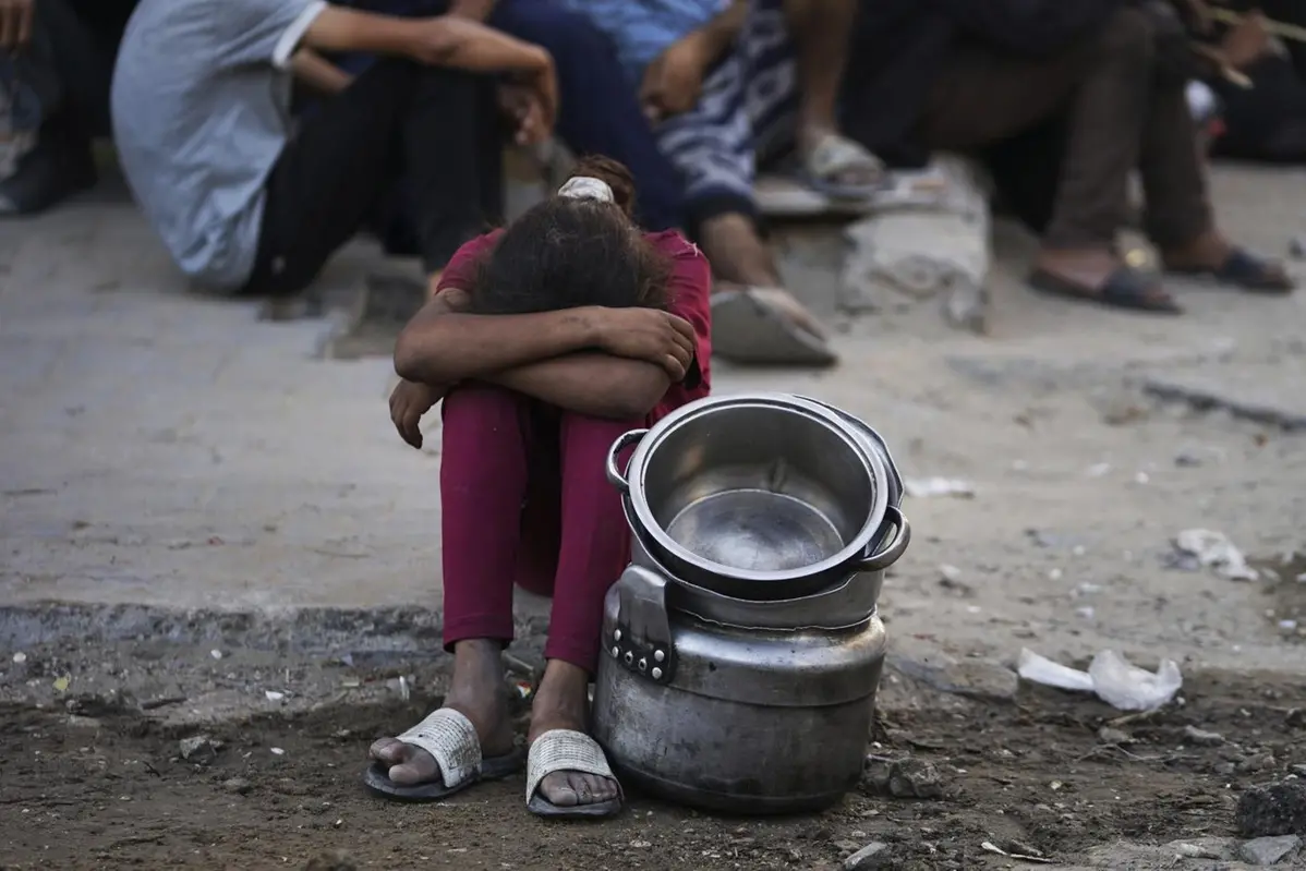 Palestinians wait for donated food at a community kitchen in Gaza City, in the northern Gaza Strip, Monday, July 14, 2025. (AP Photo/Jehad Alshrafi) , APN