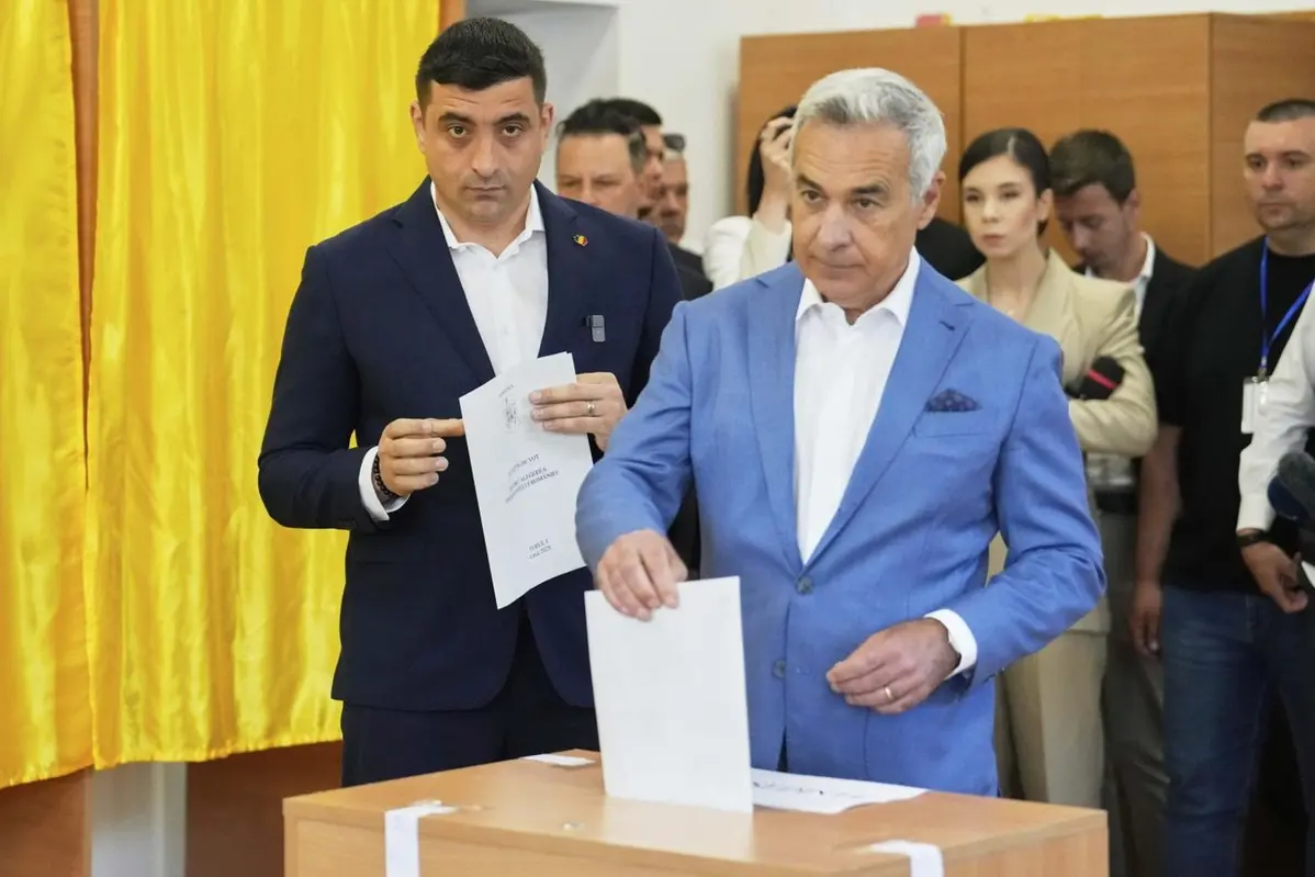 Calin Georgescu, winner of the first round of last year\\'s annulled election, right, and Presidential candidate George Simion cast their votes in the first round of the presidential election redo in Mogosoaia, Romania, Sunday, May 4, 2025. (AP Photo/Vadim Ghirda) , APN
