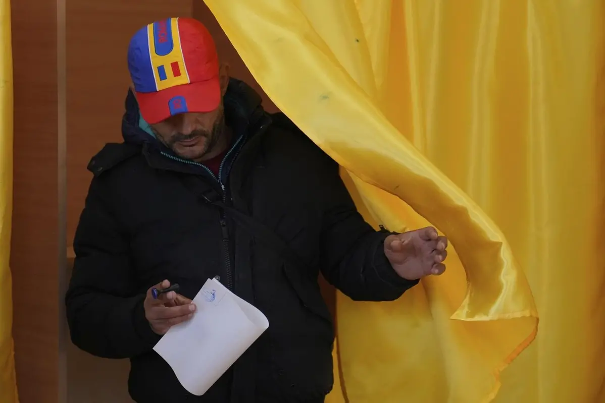 A man exits a voting cabin before casting his vote in the second round of the country\\'s presidential election redo in Mogosoaia, Romania, Sunday, May 18, 2025. (AP Photo/Vadim Ghirda) Associated Press/LaPresse , APN