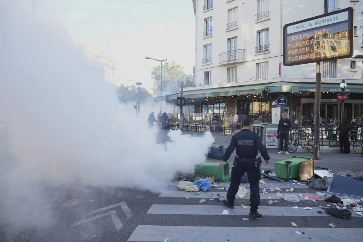 A police officer stands next to bins placed on a street to block it during the \"Bloquons Tout\" (Block Everything) protest movement in Paris, Wednesday, Sept. 10, 2025. (AP Photo/Thibault Camus) , APN