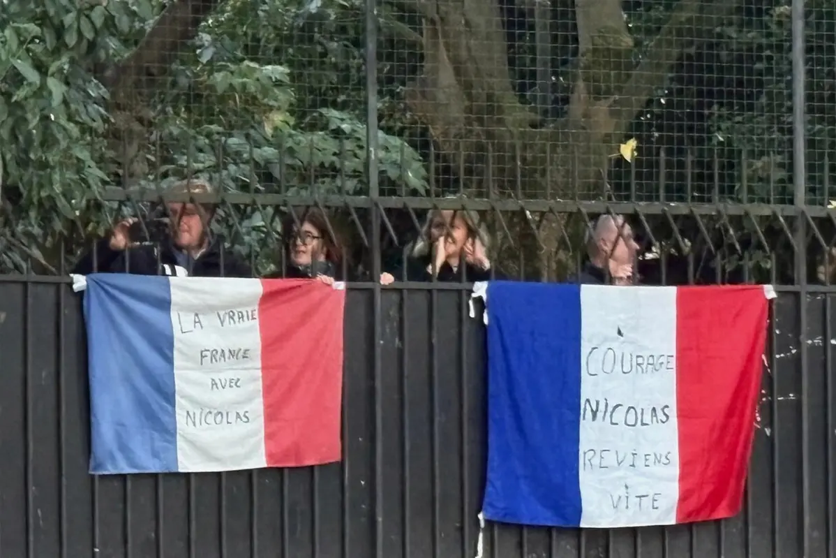 People stand behind French flags with inscription reading \\\"Courage Nicolas, come back soon\\\", right, and \\\"True France with Nicolas\\\" outside former French President Nicolas Sarkozy's home, Tuesday, Oct. 21, 2025 in Paris. Former French President Nicolas Sarkozy heads to prison to serve time for a criminal conspiracy to finance his 2007 election campaign with funds from Libya. (AP Photo/Masha Macpherson) Associated Press / LaPresseOnly italy and spain