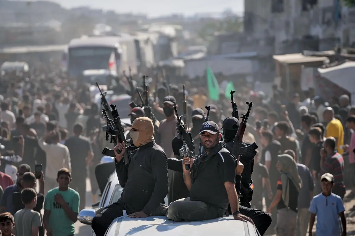 Hamas gunmen on pickup trucks escort buses carrying freed Palestinian prisoners as they are greeted following their release from Israeli jails under a cease-fire agreement between Hamas and Israel, in Khan Younis, southern Gaza Strip, Monday, Oct. 13, 2025. (AP Photo/Jehad Alshrafi) , APN
