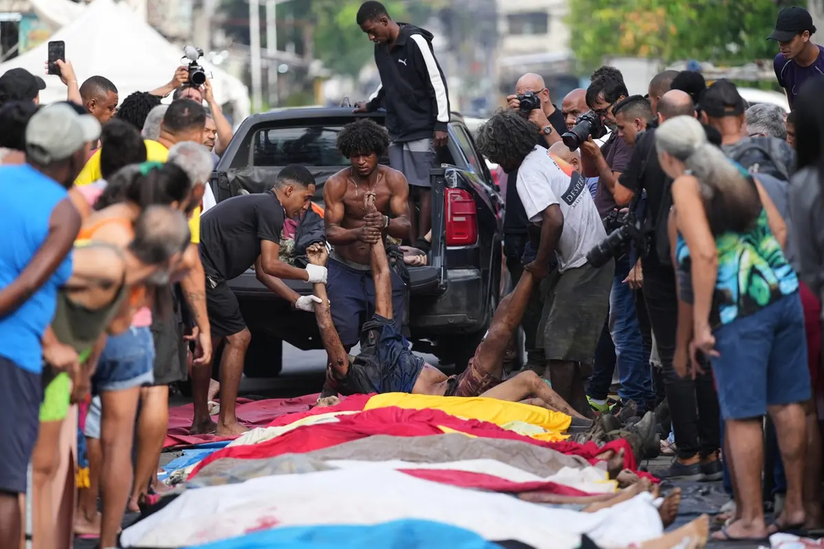 Residents line up bodies of people killed the day before during a police raid targeting the Comando Vermelho gang at the Complexo da Penha favela in Rio de Janeiro, Brazil, Wednesday, Oct. 29, 2025..(AP Photo/Silvia Izquierdo) Associated Press / LaPresse Only italy and spain , APN