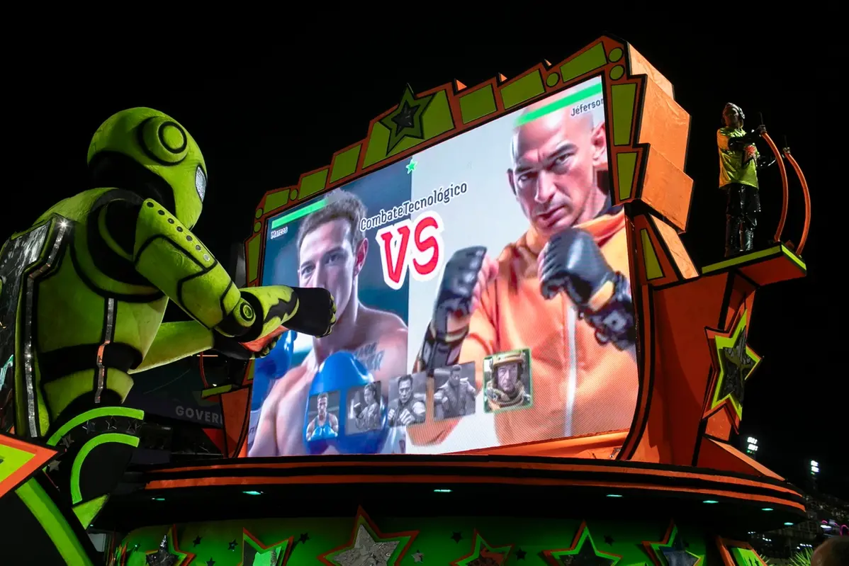 A performer from the Mocidade samba school directs a float alongside artificial intelligence images of Meta CEO Mark Zuckerberg, left, and Amazon CEO Jeff Bezos during Carnival celebrations at the Sambadrome in Rio de Janeiro, Tuesday, March 4, 2025. (AP Photo/Bruna Prado) , APN