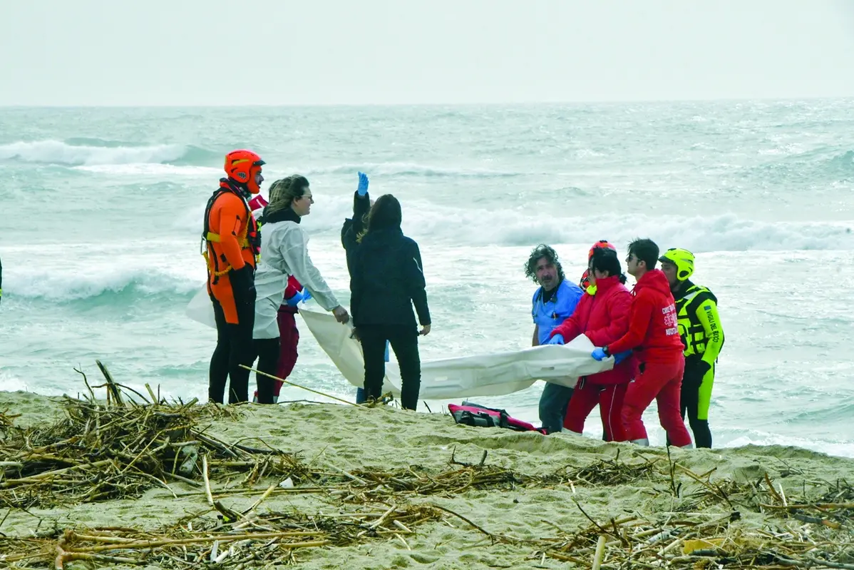 FILE - This Feb. 26, 2023 file photo shows rescuers recovering a body after a migrant boat broke apart in rough seas, at a beach in Steccato di Cutro, in the Italian southern tip, killing at least 94 people. Survivors and family members of the victims are converging in the area for a commemoration on Monday, Feb. 26, 2024, on the first anniversary of the disaster. (AP Photo/Giuseppe Pipita) Associated Press/LaPresse Only Italy and Spain , APN