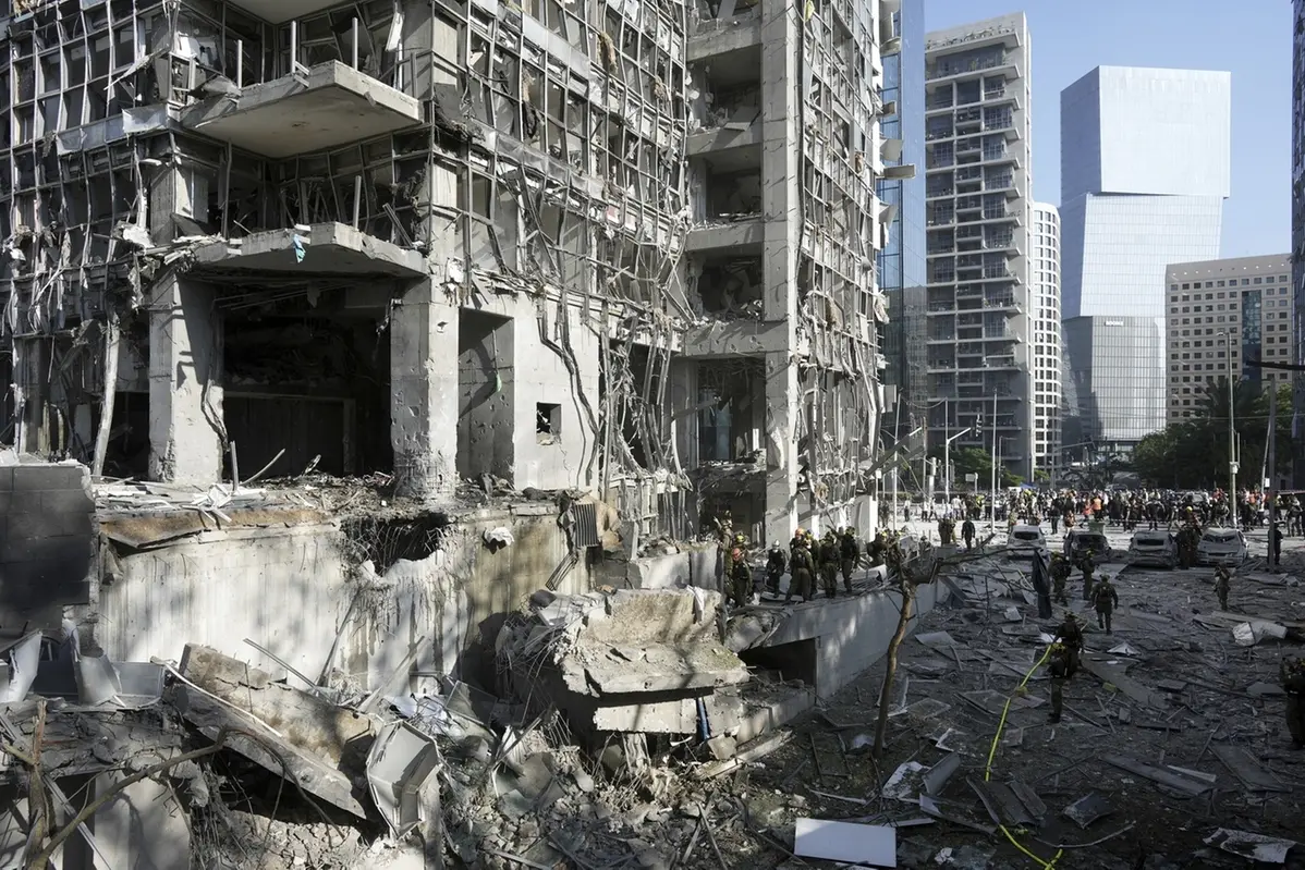 Rescue workers and military personnel inspect the site of a direct hit from an Iranian missile strike in Ramat Gan, Israel, Thursday, June 19, 2025. (AP Photo/Oded Balilty)