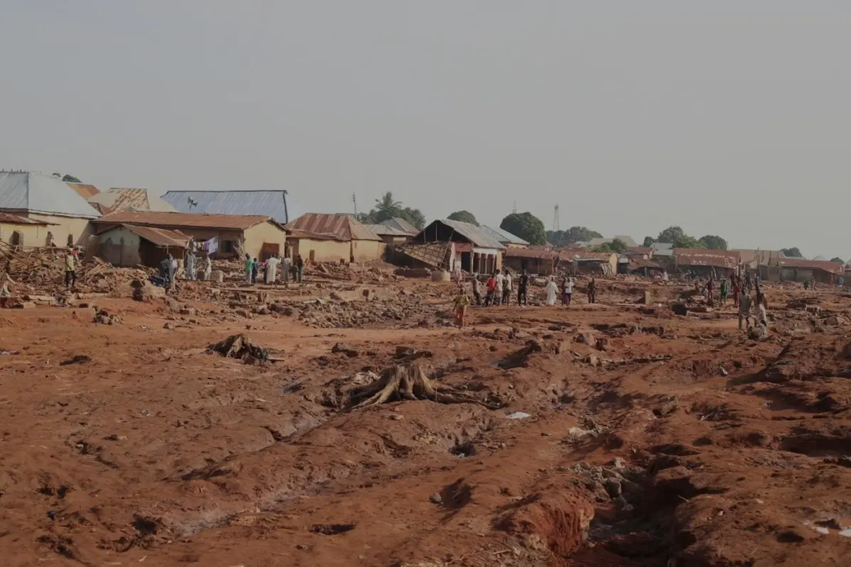 People gathered in a flooded area after heavy rainfall in the market town of Mokwa, north-central Nigeria, Saturday May 31, 2025. (AP Photo/Usman Salihu Mokwa)