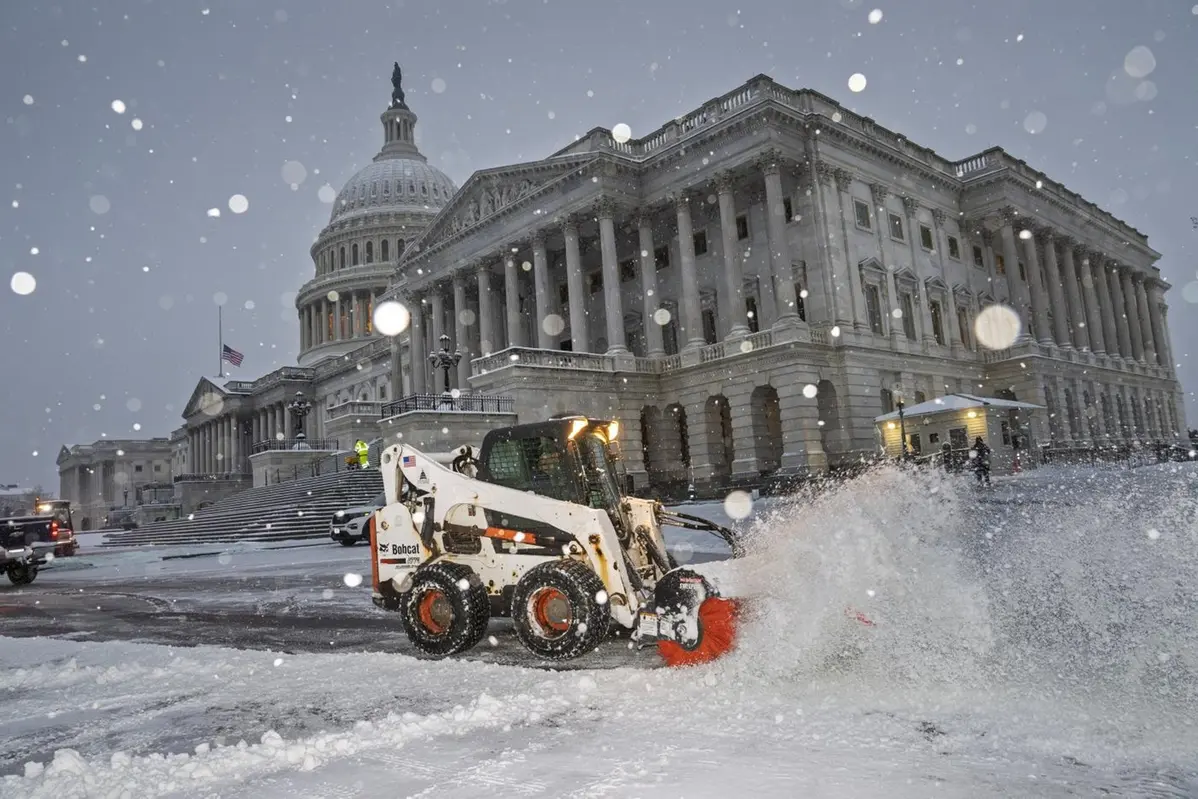 I lavoratori sgombrano la piazza del Campidoglio mentre cade la neve in vista di una sessione congiunta del Congresso per certificare i voti del Collegio elettorale alle elezioni presidenziali