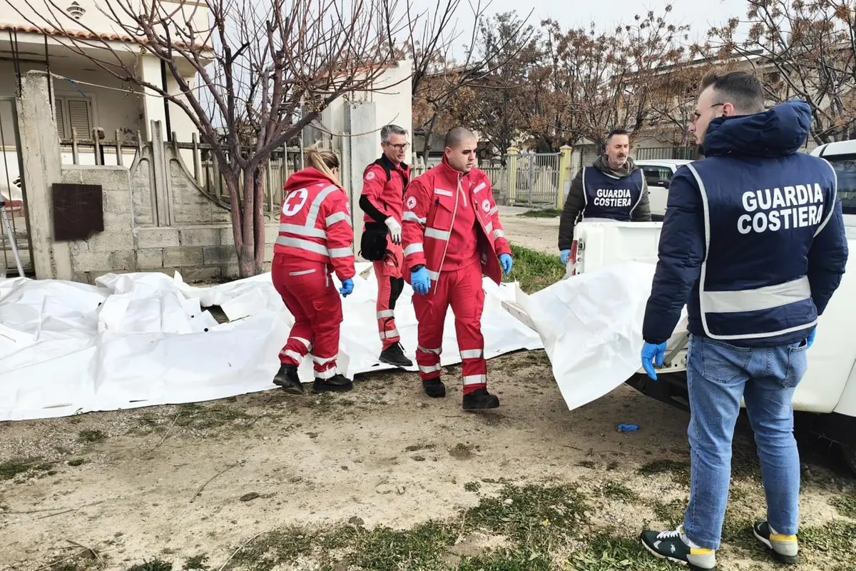 I corpi dei migranti morti in mare a Crotone coperti da un telo bianco