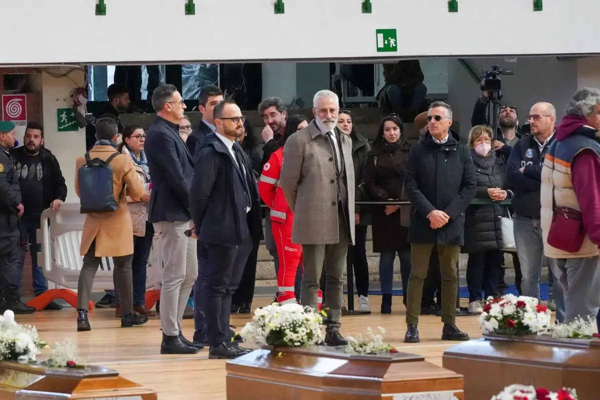 Le bare dei migranti morti in mare a largo di Crotone. Nella foto anche il procuratore Giuseppe Capoccia