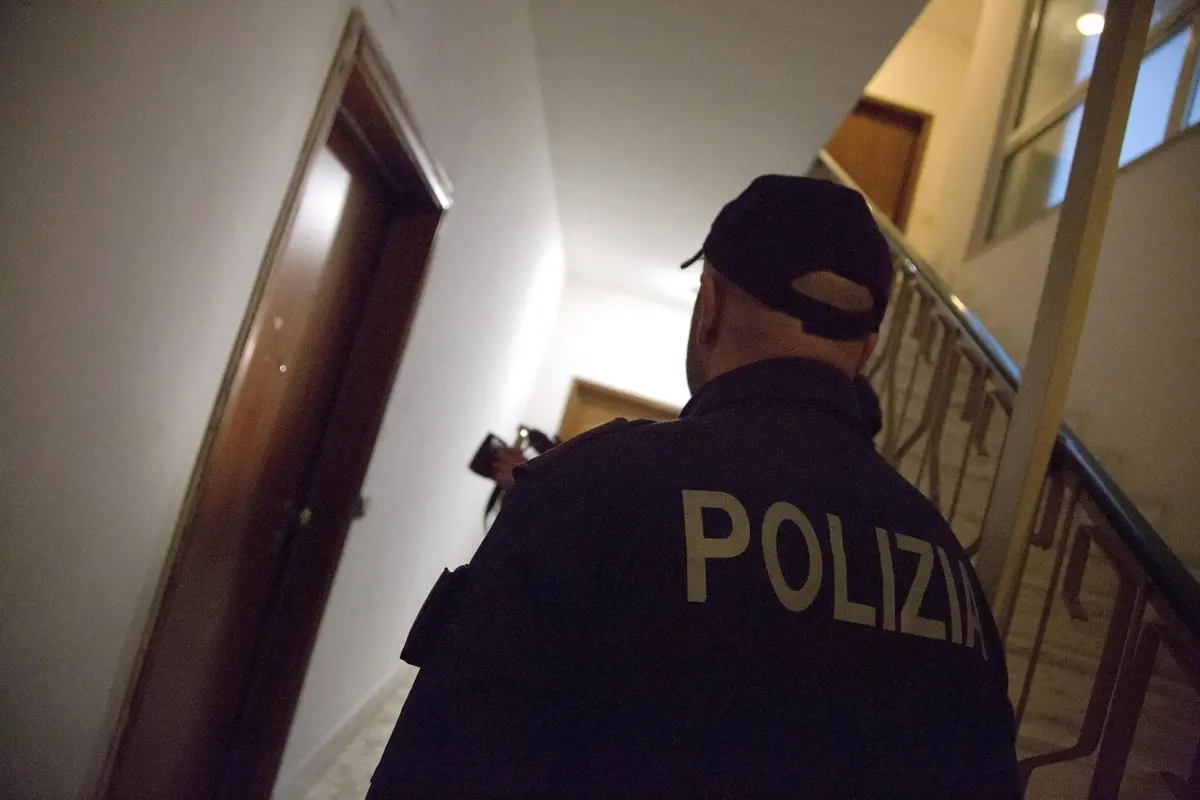 Un agente della Polizia all\\'esterno della porta di casa di un componente della famiglia Spada contro la quale sono stati esplosi cinque colpi di pistola, Ostia, 26 Novembre 2017. Poco dopo \\u00E8 stata presa a calci e pugni anche la porta di casa del fratello. ANSA/ SARA CERVELLI