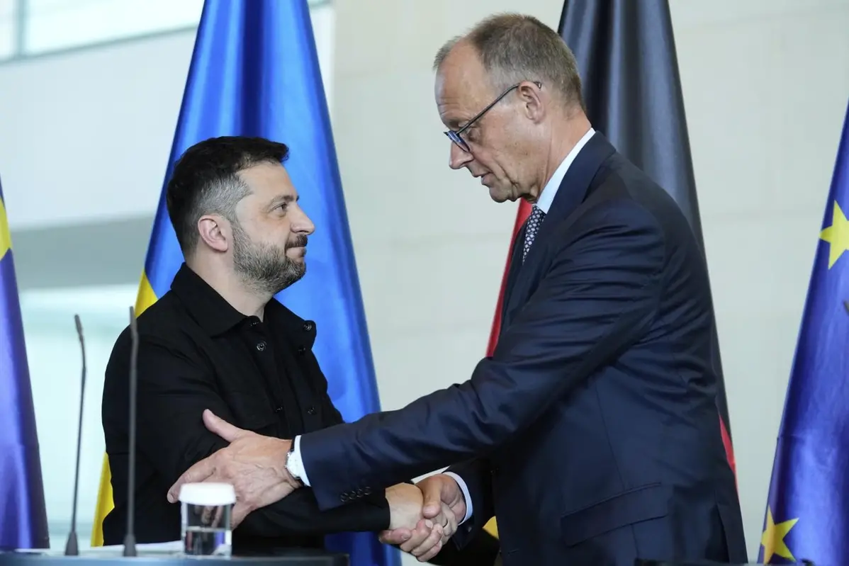 German Chancellor Friedrich Merz, right, and Ukrainian President Volodymyr Zelenskyy, left, shake hands after a joint press statement following talks with European and U.S. leaders in Berlin, Germany, Wednesday, Aug. 13, 2025. (AP Photo/Ebrahim Noroozi) , APN
