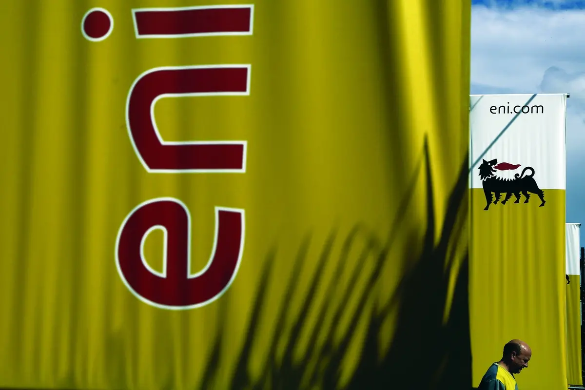 FILE - In this Friday, Feb. 23, 2018 file photo, an employee walks by banners with name and sign of energy firm Eni at Strovolos area in capital Nicosia, Cyprus. Oil giants Shell and Italy\\u2019s Eni were acquitted Wednesday, March 17, 2021 of corruption charges in a $1.1 billion bribery case involving control of a lucrative oil block on Nigeria. In addition the companies, Eni\\u2019s current CEO, his predecessor and a former Nigerian oil minister were among 13 defendants acquitted in the three-year-old trial, involving the 2011 purchase of the OPL245 block. (AP Photo/Petros Karadjias, File) , AP