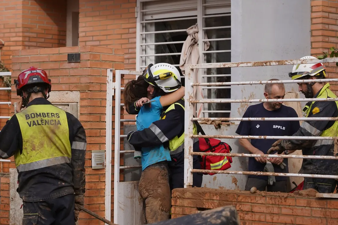 A woman hugs a firefighter after floods in Massanassa, just outside of Valencia, Spain, Friday, Nov. 1, 2024. (AP Photo/Alberto Saiz) , APN