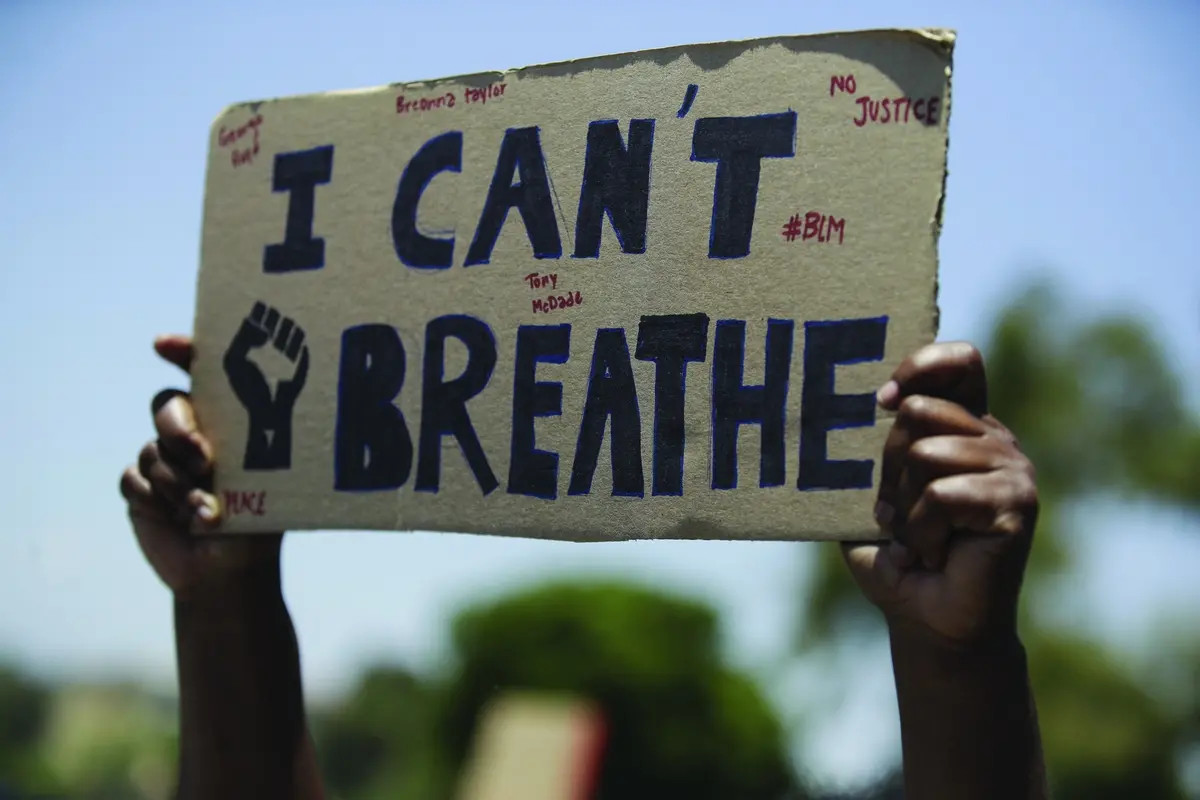 A demonstrators holds a sign Thursday June, 4, 2020 in Santa Clarita, Calif., during a protest over the death of George Floyd who died May 25 after he was restrained by Minneapolis police. (AP Photo/Marcio Jose Sanchez)